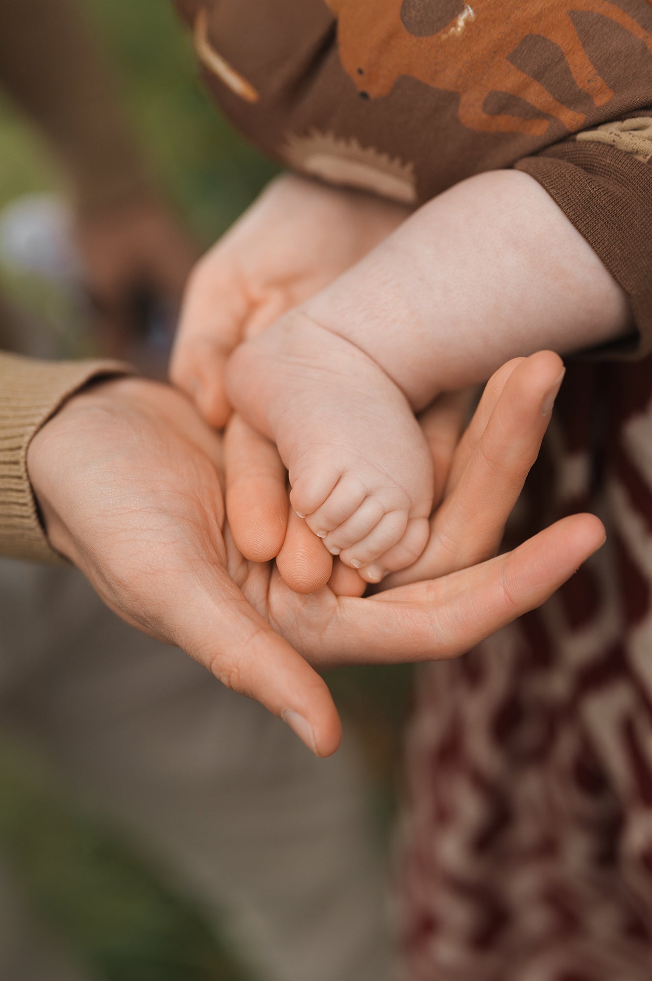 Elternhände halten kleine Babyfüße – Sinnbild für Nähe und Familie bei Kibimemories